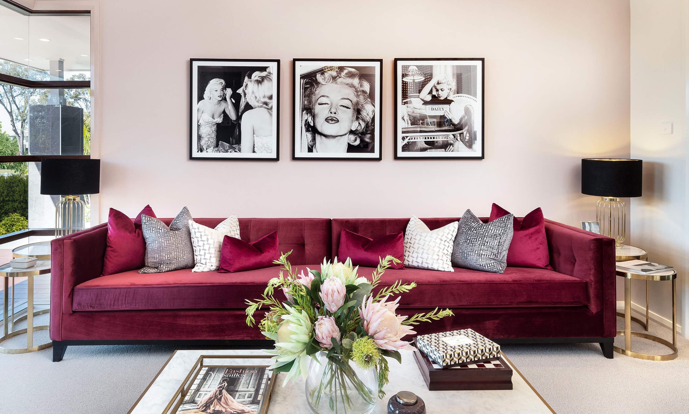 Luxe Glamour styling showcases brilliant metallics, glass, mirrored furniture and elegant fabrics and accent colours like the crimson sofa in this home theatre.