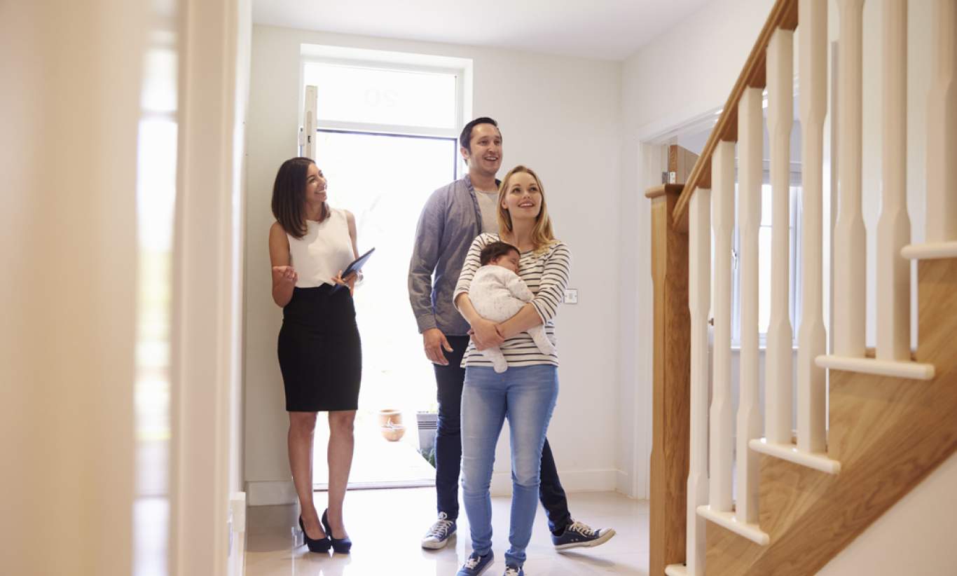 Realtor Showing Young Family Around Property For Sale