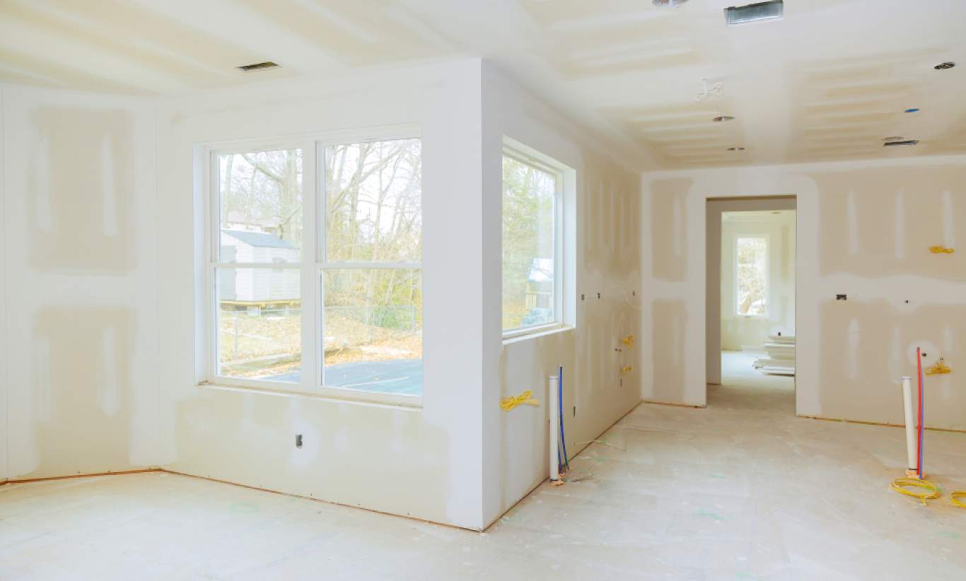 Interior construction of housing project with drywall installed and patched without painting applied