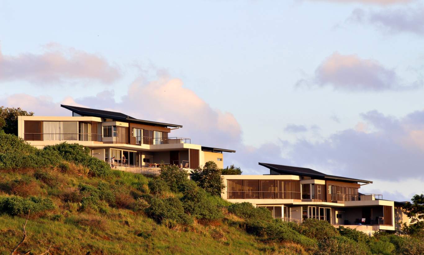 Two similar mansions built into a sloping hill