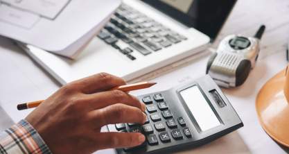 Businessman calculating budget before signing real estate project contract with house and car model at the table in the office