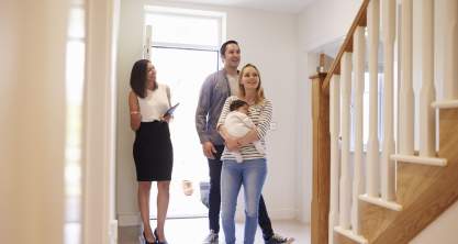 Realtor Showing Young Family Around Property For Sale