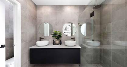 Dark and modern bathroom with gray wall tiles, stone like washbasin and big mirror